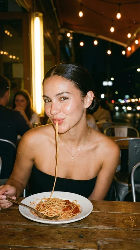 AI-generated romantic couple sharing a spaghetti kiss moment at a candlelit outdoor table under warm amber string lights at night with soft bokeh background variation 2